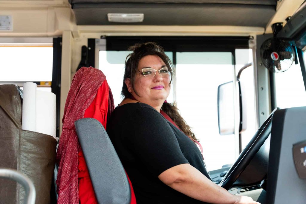 La conductora de autobús Annette sentada en un autobús escolar
